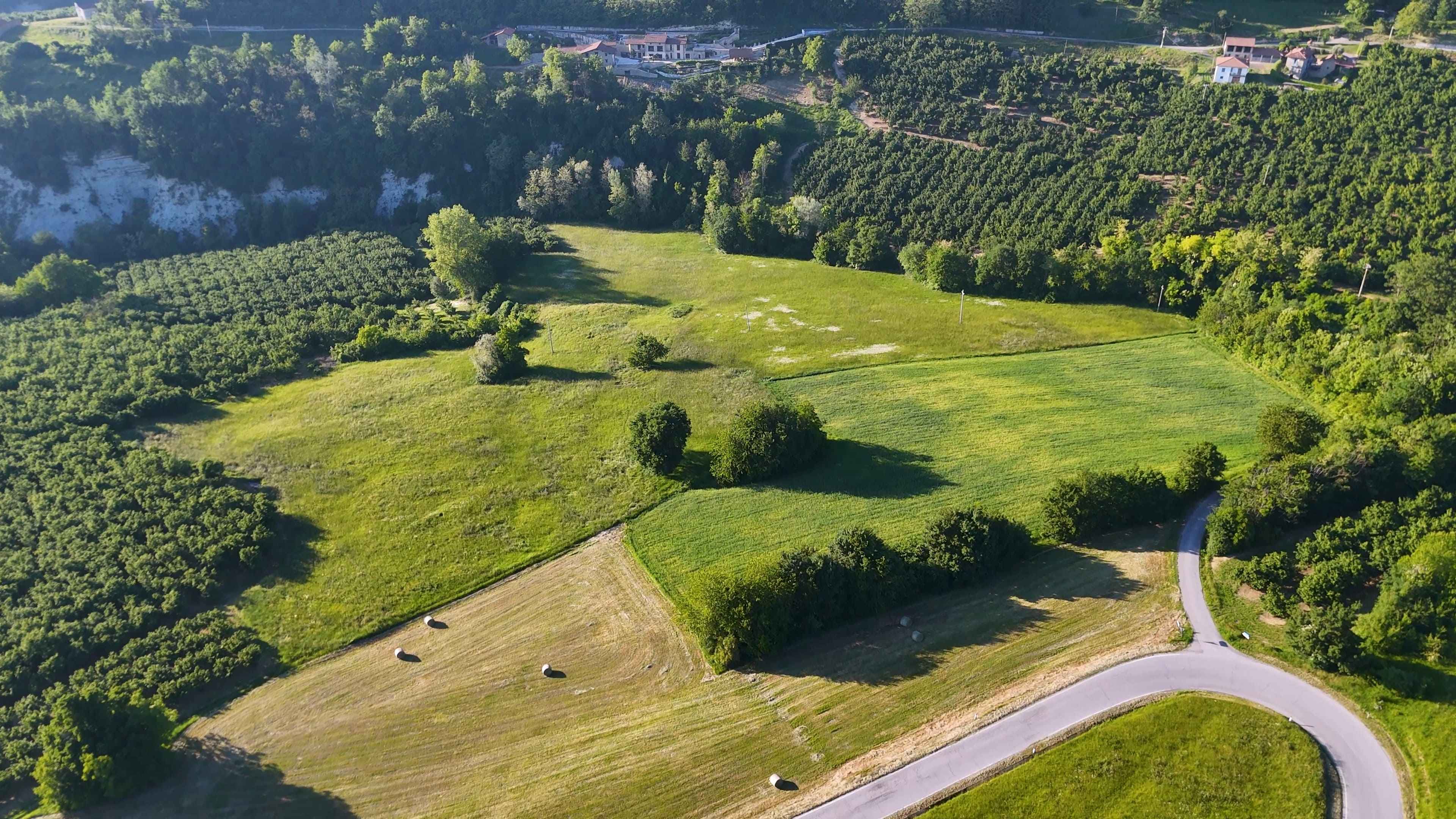 aerial-view-winding-road-through-green-italian-countryside-hills (1) (1)